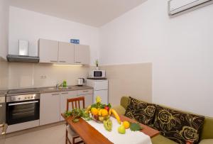 a kitchen with a table with a bowl of fruit on it at Studio Apartment Brigita in Mlini
