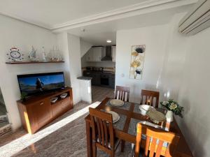 a living room with a dining room table and a television at Apartment Rayo Dorado in Orihuela Costa