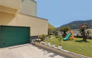 a garage with a green garage door and a playground at Casa Manuela in Marinella di Sarzana +16 photos