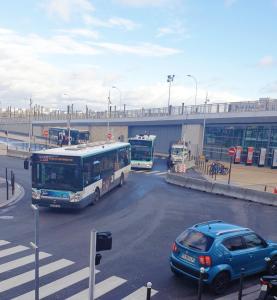 Un autobús y un coche conduciendo por una calle en Paris 12mn, Orly 10mn Superbe chambre privée, en Juvisy-sur-Orge