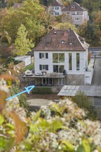 a white house with a blue arrow in front of it at Ferienwohnung stadtnah mit Weinbergblick in Würzburg