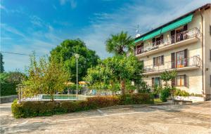 a building with a balcony and trees in front of it at Appartamento Romano in Verbania