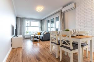 een eetkamer en een woonkamer met een tafel en stoelen bij WrocApartments StarCenter in Wrocław