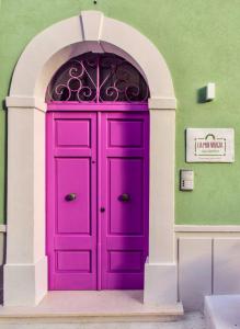 a purple door in a building with an archway at B&B La Mia Valigia in San Lucido