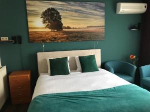 um quarto com uma cama com um quadro na parede em Wapen van Exloo em Exloo