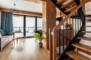 a living room with a staircase leading to a living room at FAJNE CHATY - rodzinny wypoczynek w górach in Falsztyn