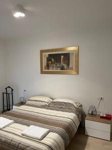 a bedroom with two beds and a picture on the wall at HOUSE RODRIGUEZ in San Lazzaro di Savena
