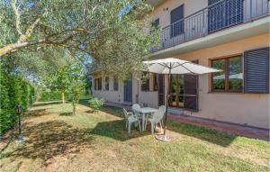 a table with an umbrella in the yard of a house at Stunning Apartment In Castiglione Del Lago With 2 Bedrooms, Wifi And Outdoor Swimming Pool in Casamaggiore