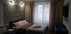 a bedroom with a bed in front of a window at Old Town Studio Apartment in Toruń