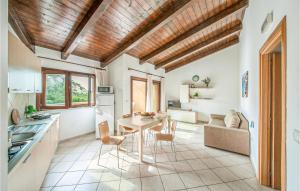 una cucina e un soggiorno con soffitto in legno di Awesome Apartment In Trinitadagultu Ot With Kitchen a Trinità dʼAgultu