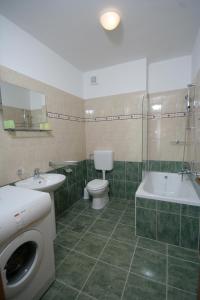 a bathroom with a toilet and a sink and a washing machine at Apartments Mavarcica in Trogir