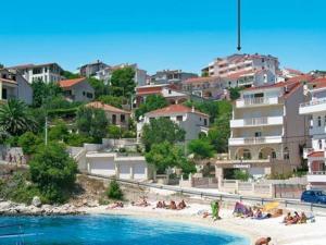 a group of people on a beach with buildings at Apartments Mavarcica in Trogir