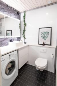 uma casa de banho com uma máquina de lavar roupa e um lavatório em Modern design w/balcony, free parking,WiFi & A/C em Lappeenranta
