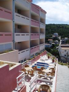 a balcony of a building with chairs and a swimming pool at Apartments Mavarcica in Trogir
