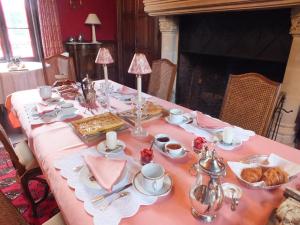 a table with a pink table cloth with pastries on it at Château de Nazé Vivy-Saumur in Vivy