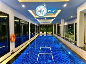 a swimming pool in the middle of a building at The Vet Boutique Hotel - SHA Extra Plus in San Kamphaeng
