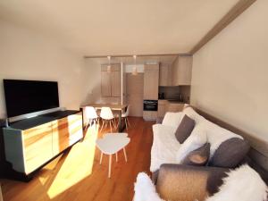 a living room with a couch and a table at Douglas - Appartement au cœur du Jardin Alpin in Courchevel