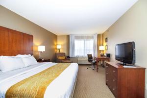 a hotel room with a bed and a flat screen tv at Comfort Inn & Suites East Moline near I-80 in East Moline