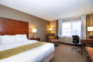 a hotel room with a bed and a desk at Comfort Inn & Suites East Moline near I-80 in East Moline