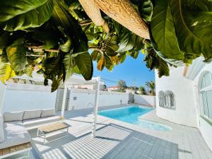 a villa with a swimming pool and a palm tree at Villa “Castellón“ in Miami Platja