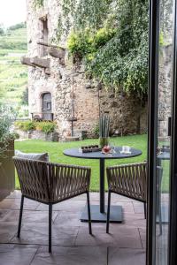 a patio with a table and two chairs and a table at Relais et Châteaux Le Chambard in Kaysersberg