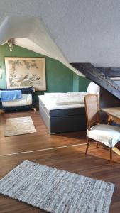 een slaapkamer met 2 bedden, een stoel en een tafel bij myNest Appartements in Seefeld in Tirol