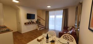 een woonkamer met een tafel en stoelen en een televisie bij Weingut & Ferienwohnungen Lenhard in Lang