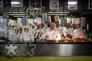 a group of chefs standing behind a counter in a kitchen at Relais et Châteaux Le Chambard in Kaysersberg +88 photos