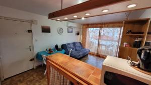 eine Küche und ein Wohnzimmer mit einem Sofa und einem Tisch in der Unterkunft Hollywood E24 - T2 avec terrasse à 2 minutes de la plage in Valras-Plage