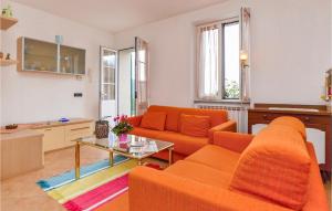 ein Wohnzimmer mit einem orangenen Sofa und einem Tisch in der Unterkunft Gorgeous Apartment In Localitabracco ge With Wifi in Bracco