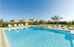 a large swimming pool with chairs and umbrellas at Mathia in Case Campanella