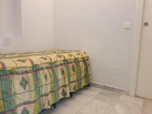 un letto in una stanza con una coperta sopra di Las Mimosas, La Cala de Mijas a La Cala de Mijas