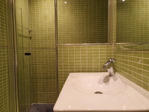 un bagno piastrellato verde con lavandino e doccia di Las Mimosas, La Cala de Mijas a La Cala de Mijas