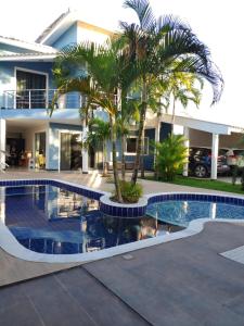 una palmera frente a una casa con piscina en Casa Porto Di Nassau, en Porto Seguro
