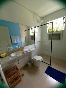 uma casa de banho com um WC, um lavatório e um chuveiro em Suítes Manjuba Praia de Sta Tereza em Ilhabela