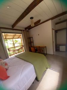 um quarto com uma cama num quarto com uma janela em Suítes Manjuba Praia de Sta Tereza em Ilhabela