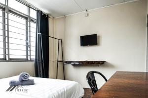 ミリにあるPermaisuri Homestay by Evernentのベッド、テーブル、テレビが備わる客室です。
