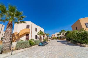 ulica z palmami i budynek w obiekcie Elimi Favignana Apartments - Residence in città w mieście Favignana