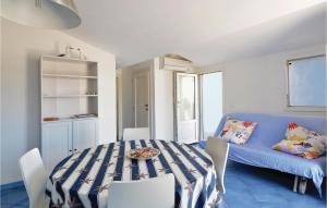 una sala da pranzo con un tavolo e un divano blu di Lovely Apartment In Punta Braccetto Rg a Punta Braccetto
