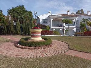 a vase on a brick circle in front of a house at Le joyau Andalou in Estepona