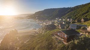 um grupo de casas numa colina junto ao oceano em Strandhuis em Eersterivierstrand