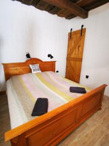 sypialnia z drewnianym łóżkiem i drewnianymi drzwiami w obiekcie Őrség Kincse Nagy Apartman - 6 főre w mieście Hegyhátszentjakab