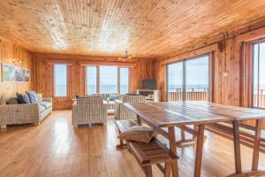 a large wooden room with a table and chairs at Strandhuis in Eersterivierstrand