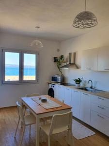 cocina con mesa, mesa y sillas en Sky and Sea Apartment Calasetta, en Calasetta