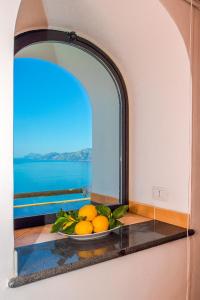 un tazón de naranjas sentado en un alféizar de la ventana en Casa Cinque, en Praiano