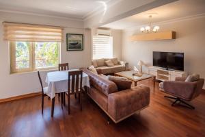 a living room with a table and a couch and a television at Vira Apart Suites in Göcek