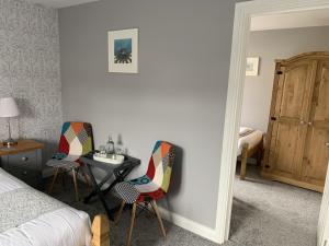 a bedroom with two chairs and a table and a bed at Hensleigh House in Charmouth