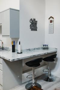 a kitchen with a counter with two bar stools at Hullidays-Theatre Hideout Apartment in Hull