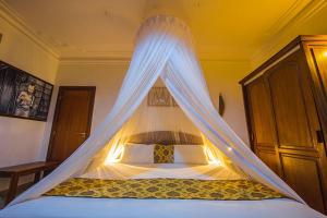 a bedroom with a bed with a mosquito net at Hotel Chez Lando in Kigali
