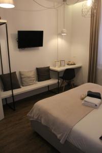 a bedroom with a bed and a desk and a tv at St. Peter's Luxury Rooms in Rome